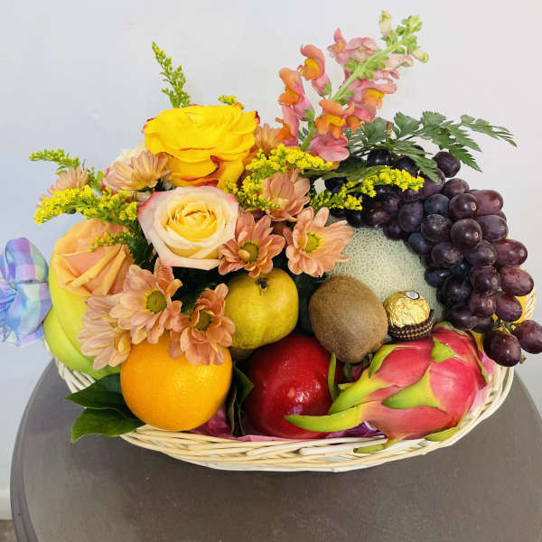Fruit basket with roses, daisies, and grapes