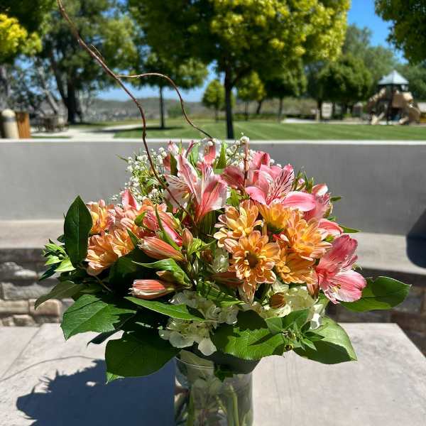 Pink and peach mixed bouquet in a clear glass vase