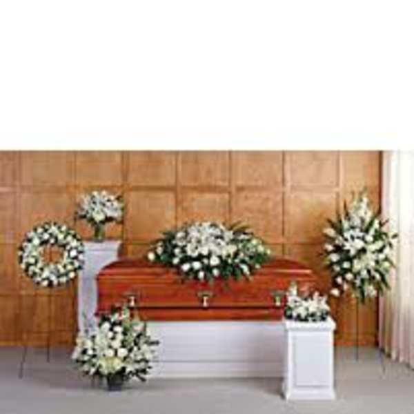 White funeral floral sprays and wreaths around a casket
