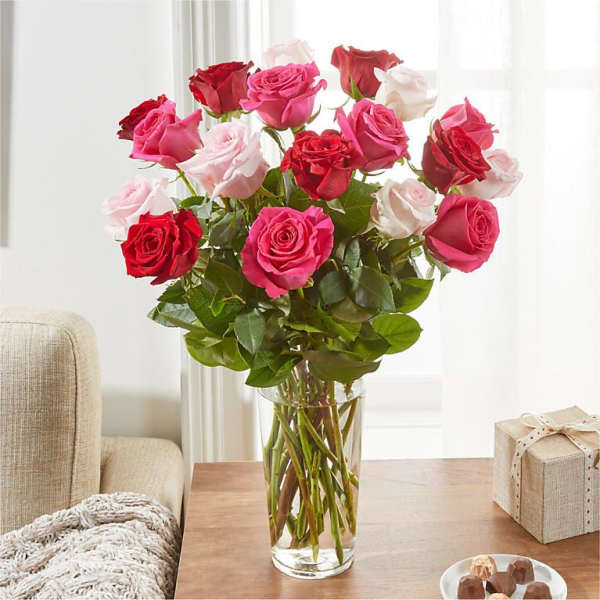 Bouquet of red, pink, and white roses in a clear glass vase