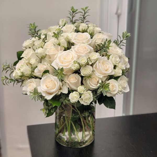 Cream roses arranged in a clear glass vase