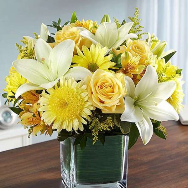 Yellow and white bouquet in a square glass vase