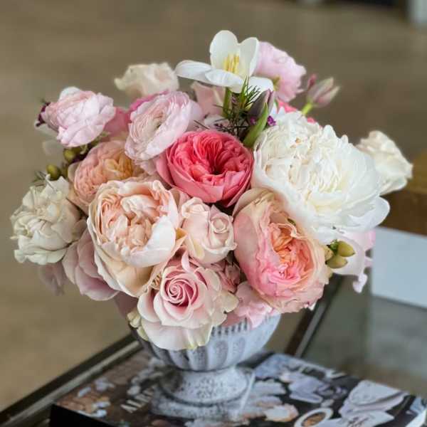 Pink and white rose bouquet in a decorative urn vase