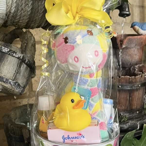 Baby gift basket with a plush toy, rubber duck, and toiletries