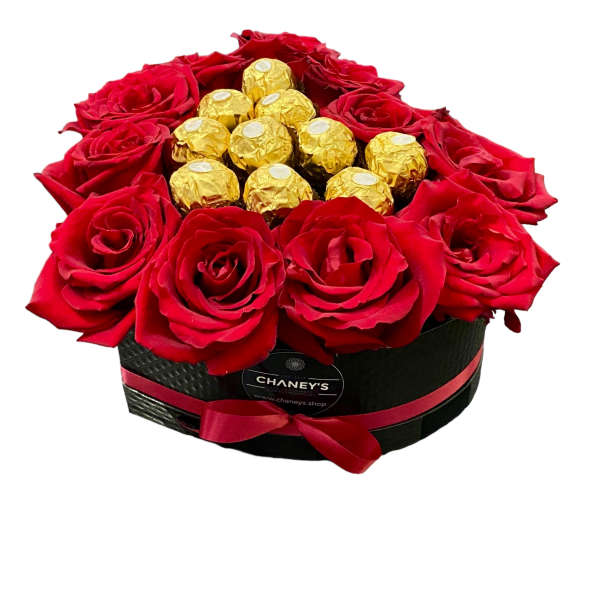 Red roses arranged around gold-wrapped chocolates in a black box