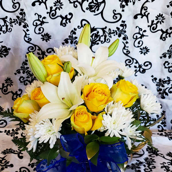 Yellow roses and white lilies in a bouquet with a blue ribbon