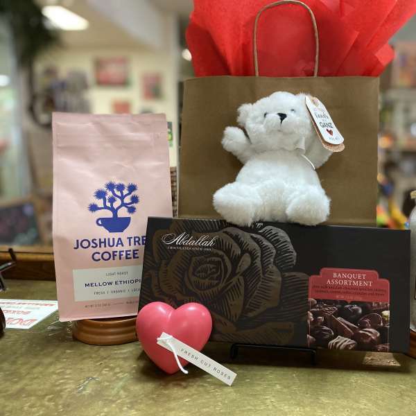 Gift basket with a teddy bear, chocolates, coffee, bath crystals, and hand cream