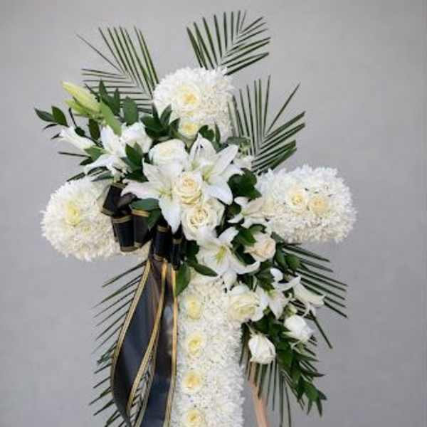 White floral standing spray with lilies and roses on an easel