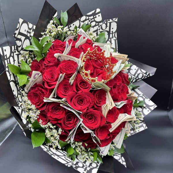Bouquet of red roses accented with folded currency and a small red crown in patterned wrap