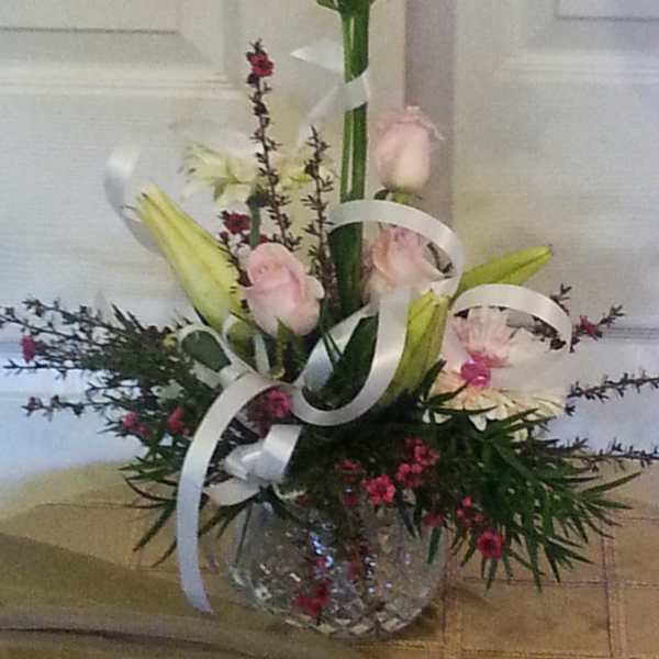Tall mixed bouquet with pink lilies and roses in a glass vase