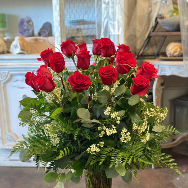Tall bouquet of red roses in a clear glass vase