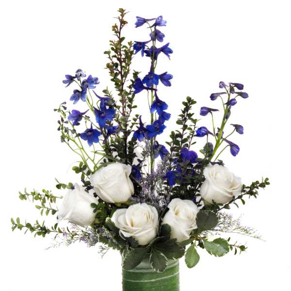 White roses and blue flowers arranged in a green glass vase