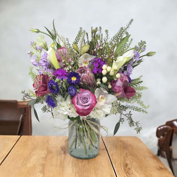 Mixed bouquet in a glass vase with pink, purple, white, and green flowers