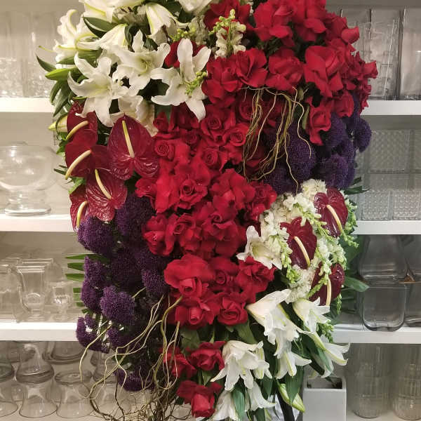 Large cascading bouquet of red and white flowers with purple accents