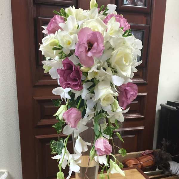 Tall bouquet of white and pink flowers in a clear vase