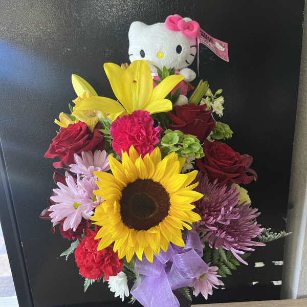 Bouquet of mixed flowers with a Hello Kitty plush in a purple vase