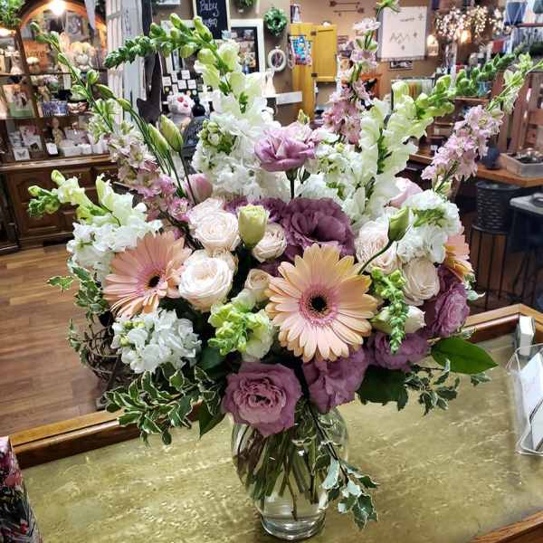 Mixed bouquet of pastel flowers in a clear glass vase