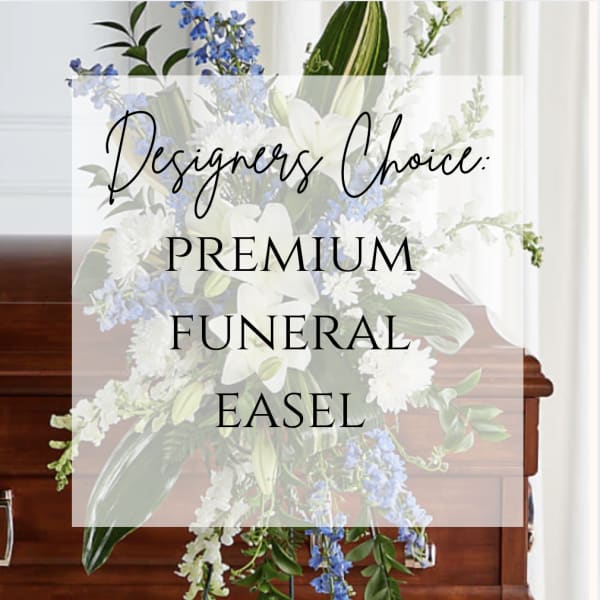 Funeral easel arrangement with white flowers and blue accents