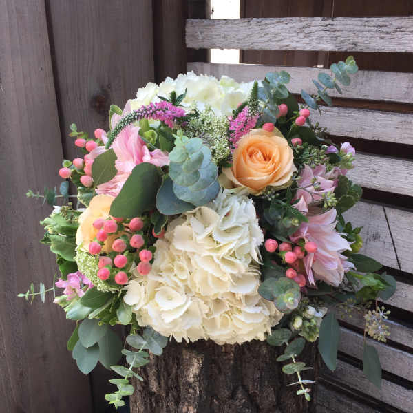 Mixed bouquet with cream hydrangeas, peach roses, and pink flowers