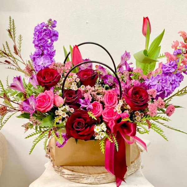Mixed bouquet of red and pink roses with purple flowers in a gift box