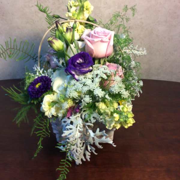 Mixed flower basket with pink and purple roses and white blooms