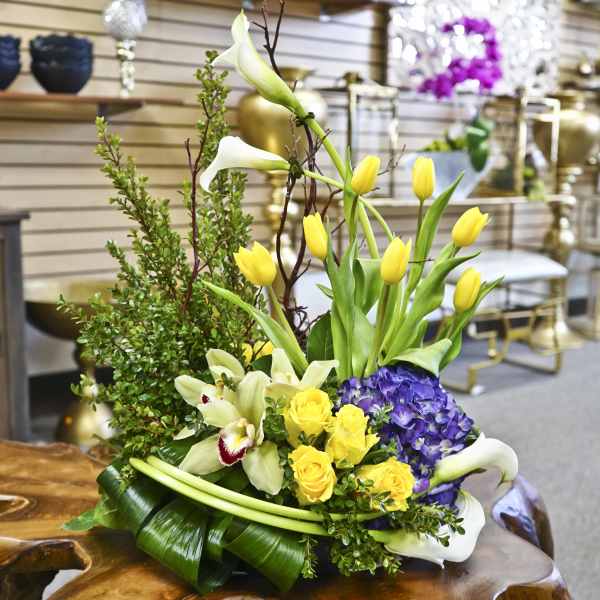 Mixed bouquet with yellow tulips, white calla lilies, purple hydrangea, and yellow roses