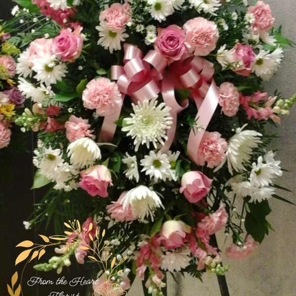 Standing floral spray with pink roses, carnations, and white daisies