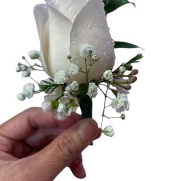 White rose boutonniere with baby's breath and greenery