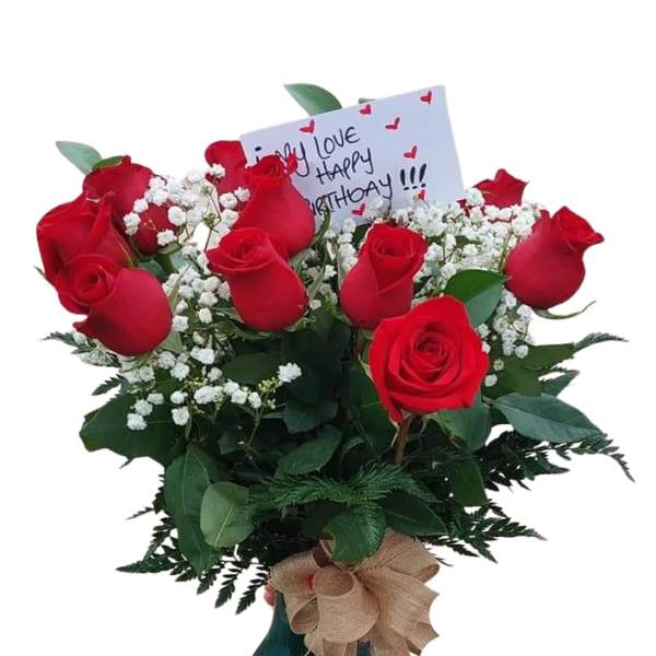 Bouquet of red roses in a vase with a birthday card