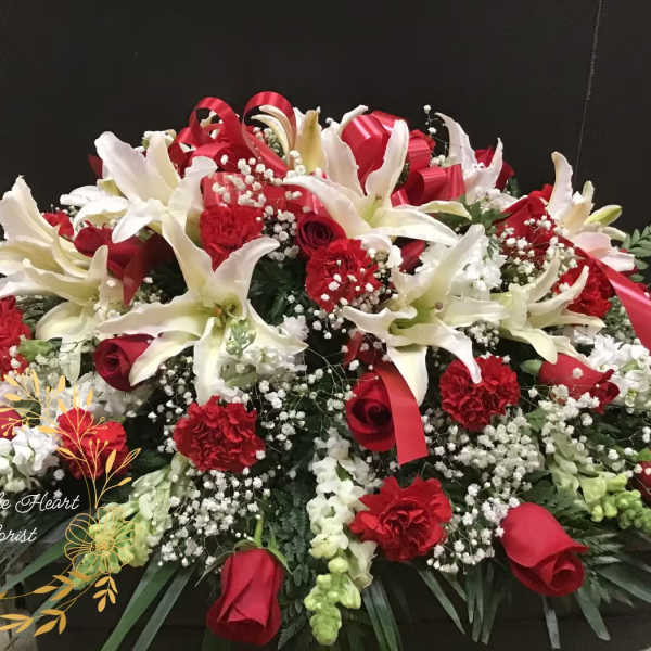 Large red and white floral arrangement with lilies, roses, and carnations
