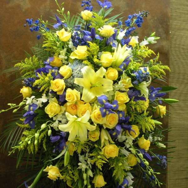 Large bouquet of yellow roses, lilies, and blue flowers