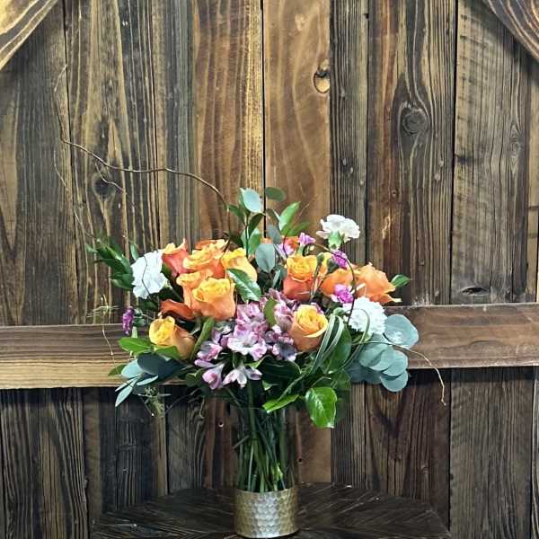 Bouquet of orange and yellow roses in a metal vase