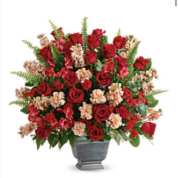 Red roses and pale carnations in a gray urn vase