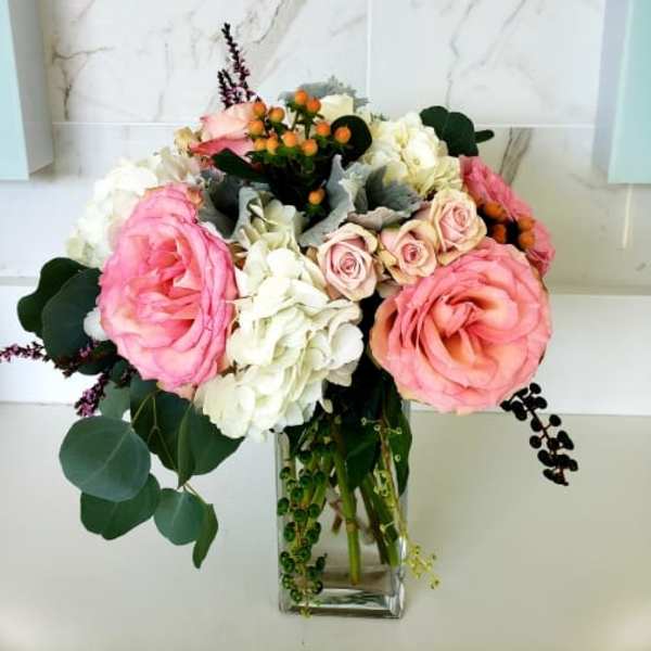 Pink and white flower bouquet in a clear glass vase