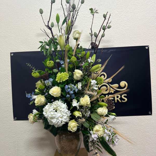 Tall floral arrangement with white roses and lilies in a vase