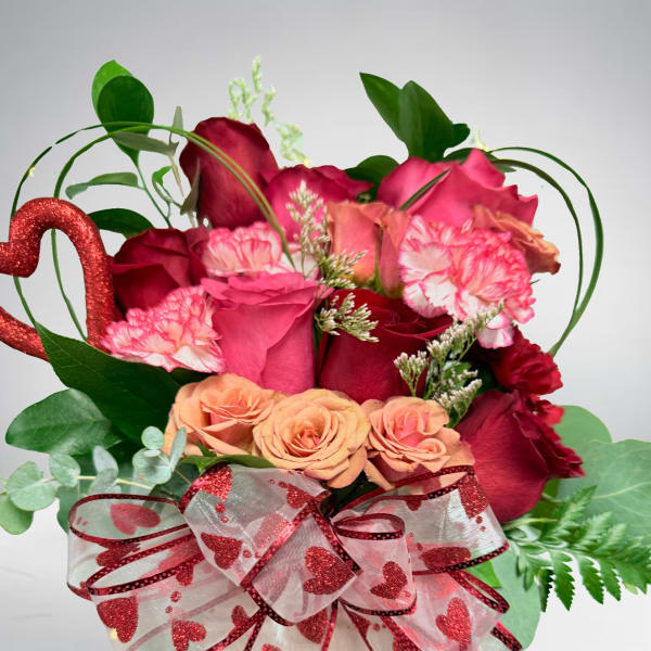 Heart-themed bouquet of red and pink roses in a white box