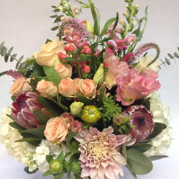 Mixed bouquet of pink, peach, and white flowers in a vase