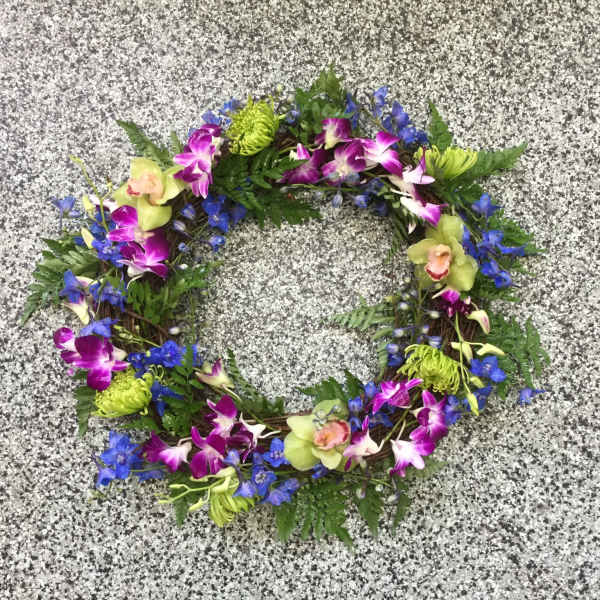 Circular floral wreath with purple orchids and blue flowers