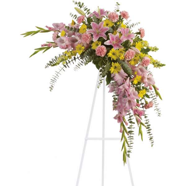 Pink and yellow floral spray on a white stand