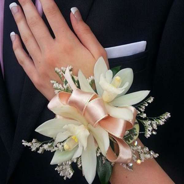 White floral corsage and boutonniere on a dark suit