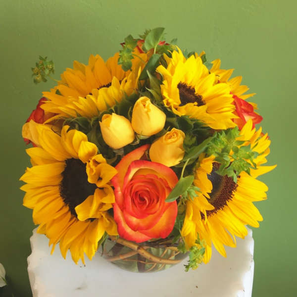 Bouquet of sunflowers and roses in a glass vase