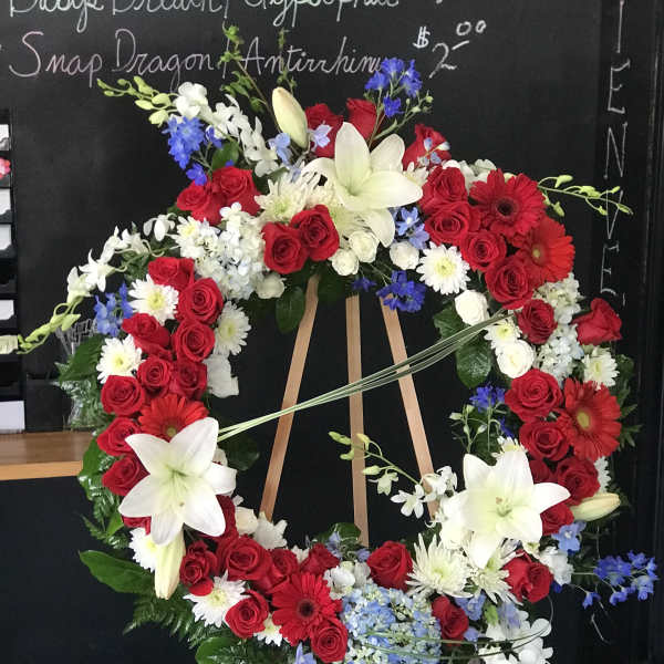 Large red, white, and blue floral wreath on an easel