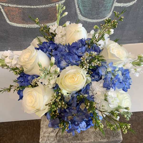 Bouquet of white roses and blue hydrangeas with small white filler flowers