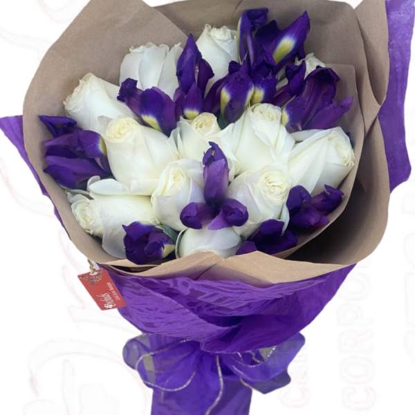Bouquet of white roses and purple irises wrapped in brown and purple paper