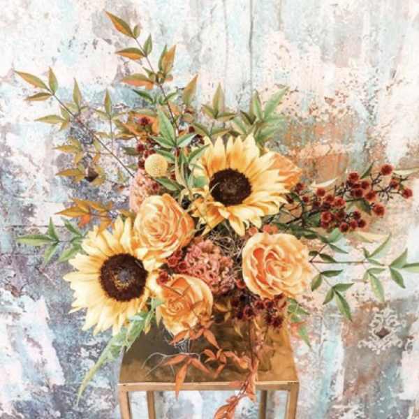Sunflowers and peach roses in a gold vase