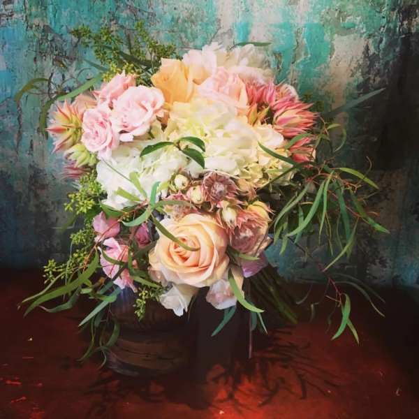 Pastel bouquet of roses and hydrangeas with trailing greenery