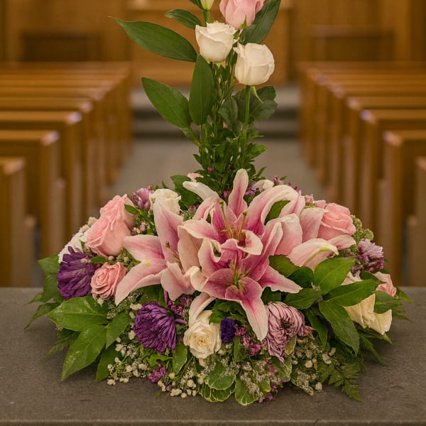 Pink lilies and roses arranged in a church setting