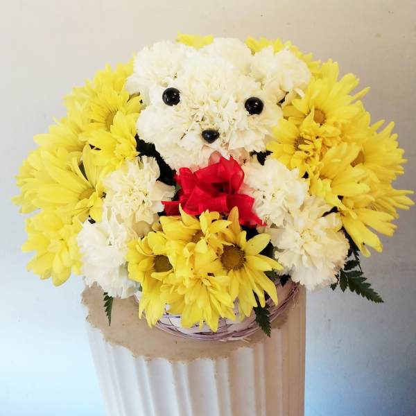 Yellow and white flower arrangement shaped like a teddy bear with a red bow