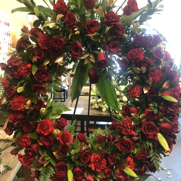 Large red rose and carnation wreath on a stand