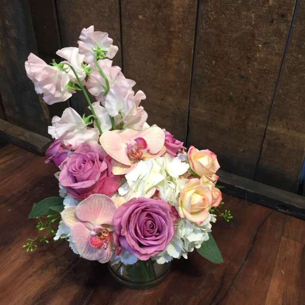 Pink and white floral arrangement in a glass vase
